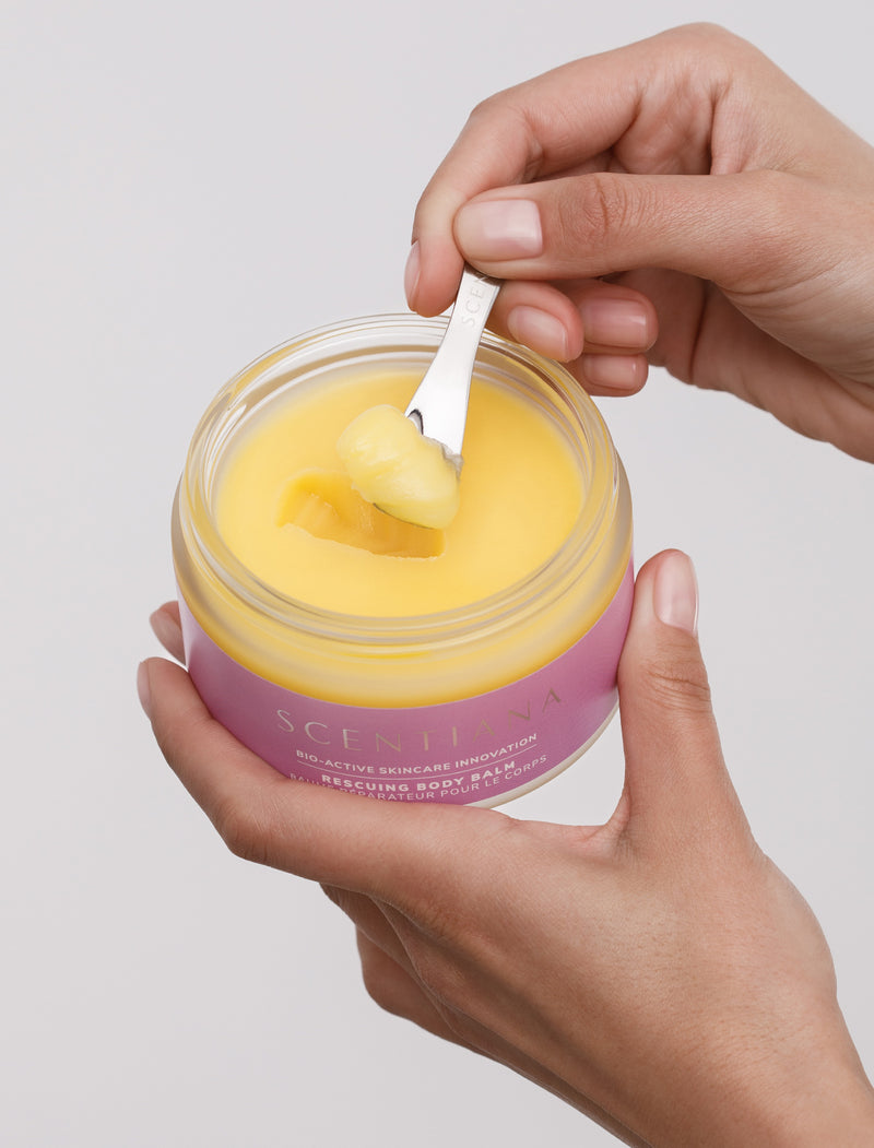 Scooping Yellow Balm Out Of Body Balm Jar