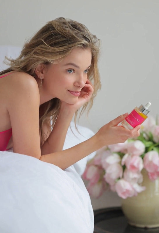 Woman Lying On Bed Holding Sensual Body Oil